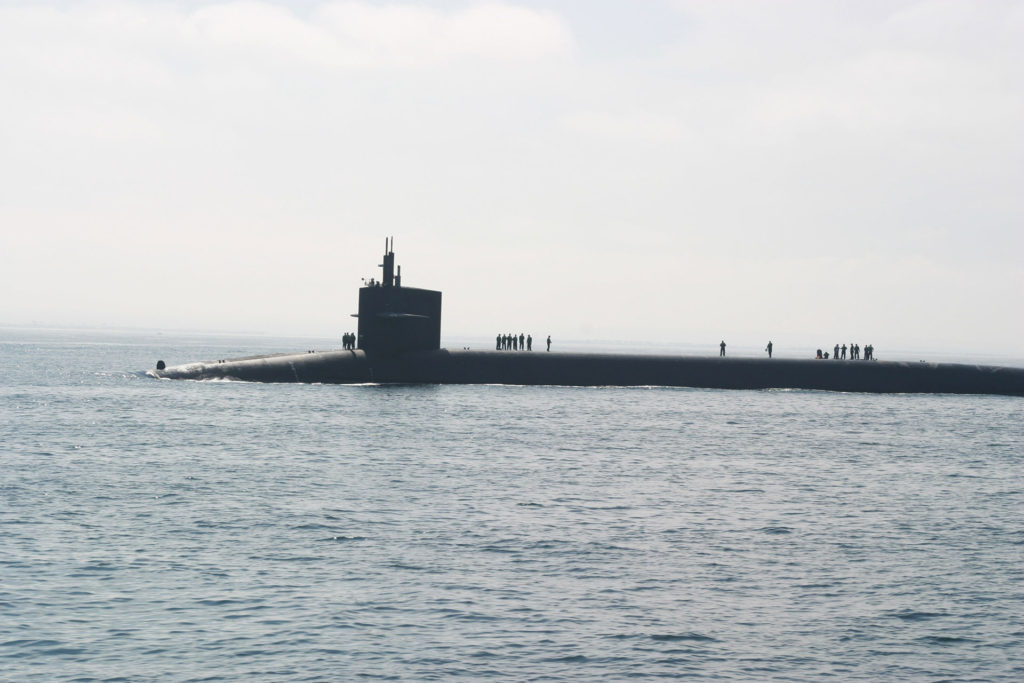 surfaced submarine in ocean with people on deck